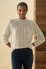 A model wearing the Dylan Cable Knit Sweater in colour Rainbow, from the front, cropped image