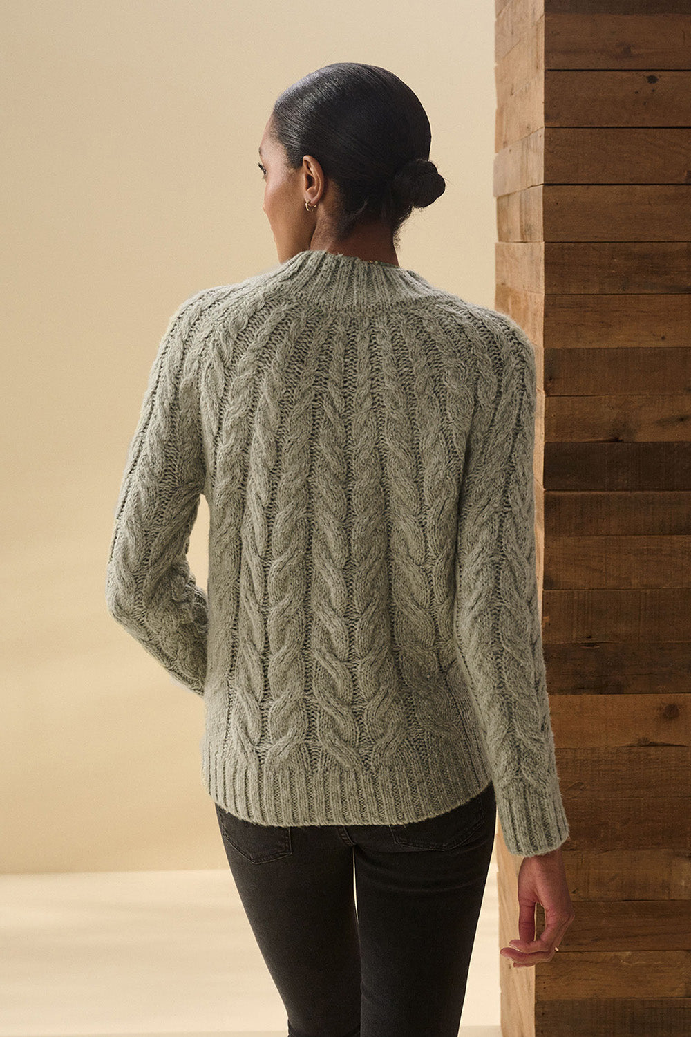 A model wearing the Dylan Cable Knit Sweater in colour Moss (Green), from the back