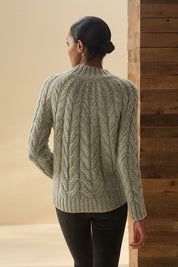 A model wearing the Dylan Cable Knit Sweater in colour Moss (Green), from the back