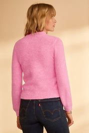 A model wearing the Petal Cable Knit Sweater in colour Raspberry (Pink), from the back