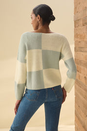 A model wearing the Monroe Sweater in colour Sageblocks (Green), from the back