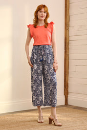 A model wearing the Cassie Pants in colour Floral (Blue), from the front, showing the whole outfit