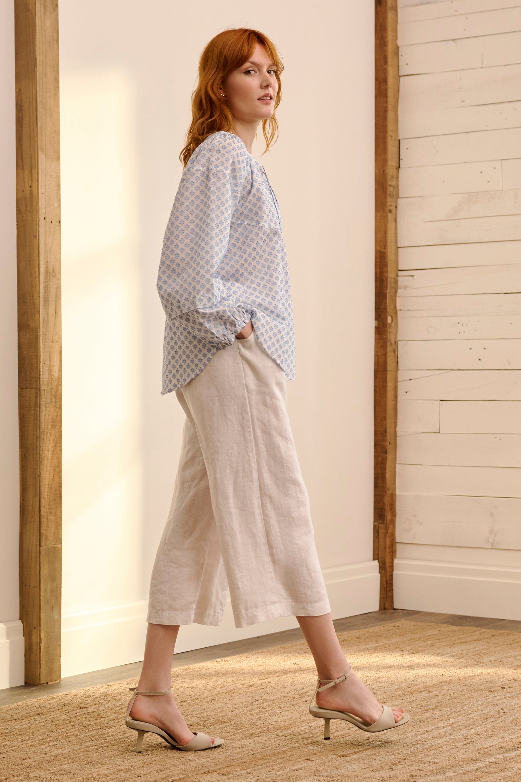 A model wearing the Naomi Cotton Blend Blouse in colour Petal (Blue), from the front, showing the whole outfit