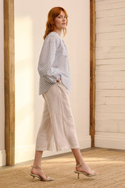 A model wearing the Naomi Cotton Blend Blouse in colour Petal (Blue), from the front, showing the whole outfit