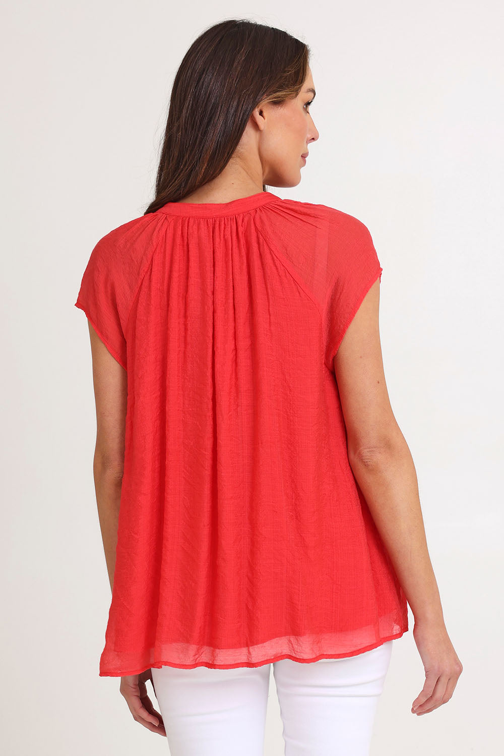 Model Madeline wearing size S of the Baja Top in colour Punch (Red), from the back