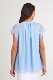 Model Madeline wearing size S of the Baja Top in colour Safira (Blue), from the back