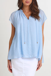 Model Madeline wearing size S of the Baja Top in colour Safira (Blue), from the front, cropped image