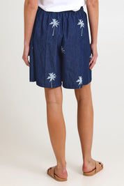Model Madeline wearing size S of the Montego Denim Short in colour Indigo (Blue), from the back