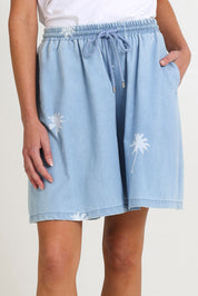 Model Madeline wearing size S of the Montego Denim Short in colour Safira (Blue), from the front, cropped image