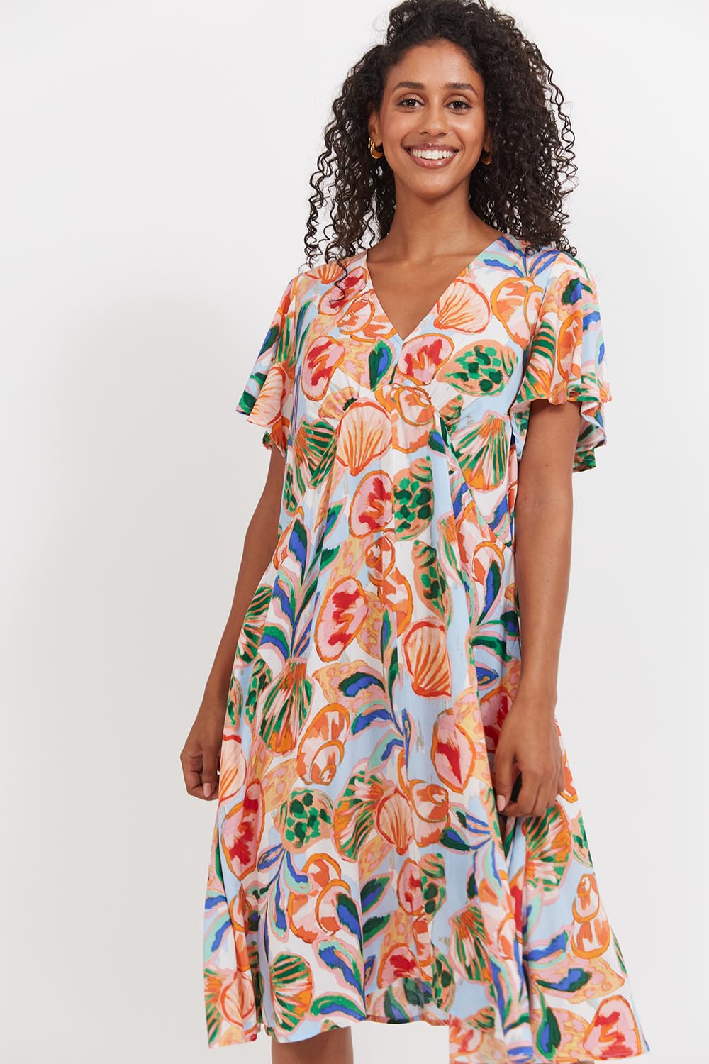A model wearing the Baja Dress in colour Tide, from the front, cropped image