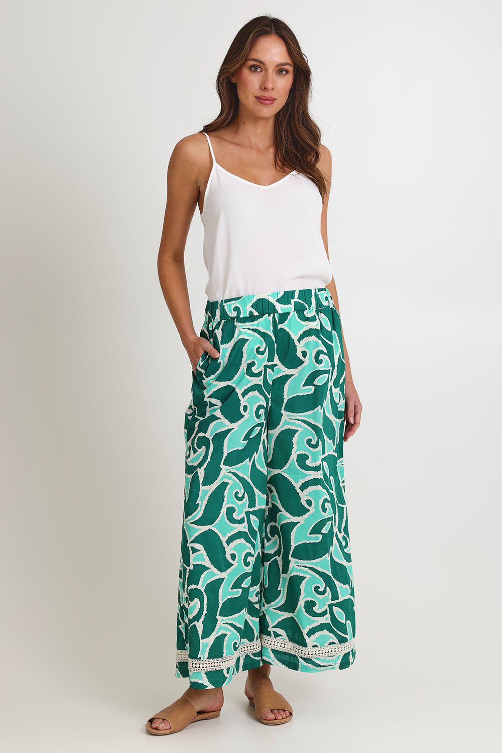 Model Madeline wearing size S of the Santos Cotton Pant in colour Amazon (Green), from the front, showing the whole outfit
