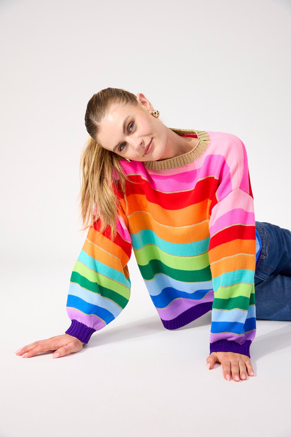 A model wearing the Niseko Jumper in colour Rainbow, from the front, cropped image