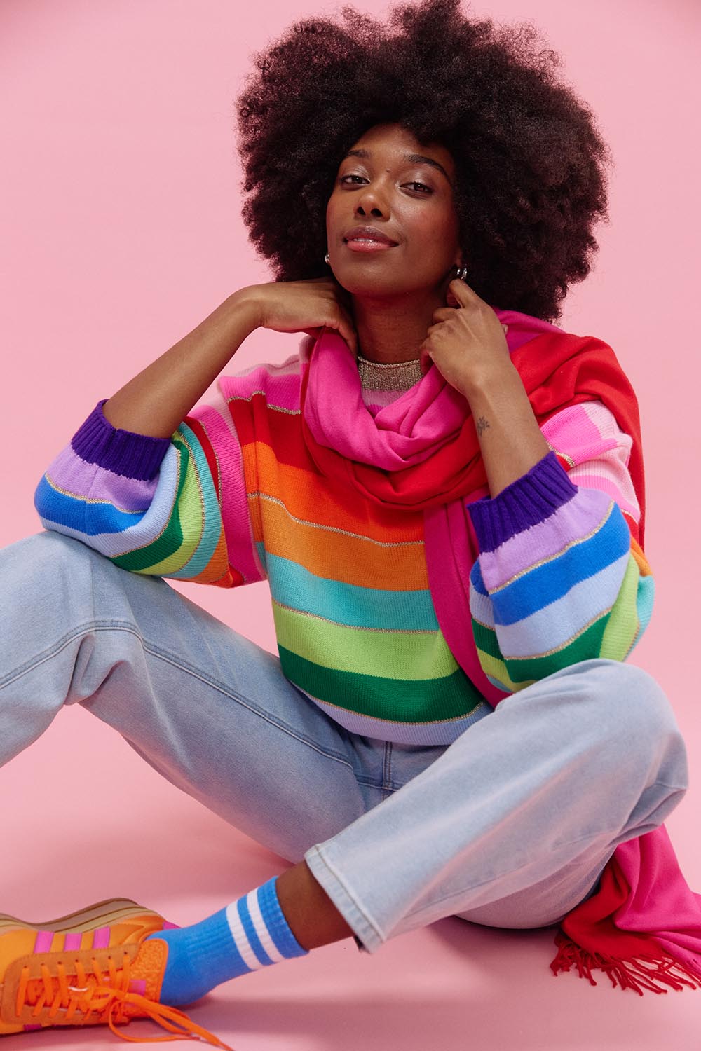 A model wearing the Niseko Jumper in colour Rainbow, from the front, showing the whole outfit