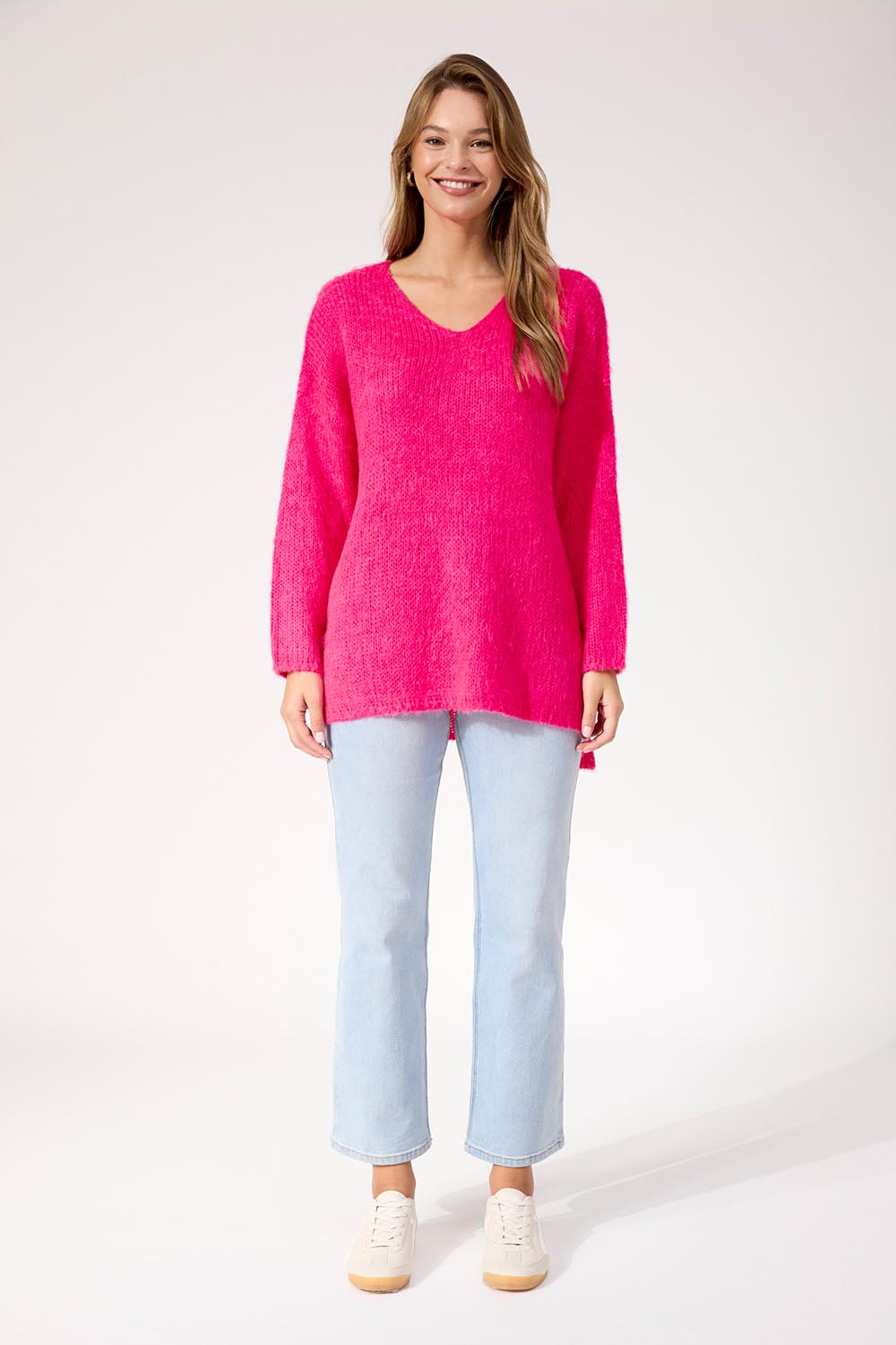 A model wearing the Lyon Relaxed Jumper in colour Hotpink (Pink), from the front, showing the whole outfit