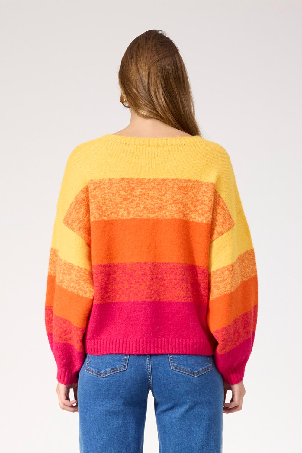 A model wearing the Valenza Jumper in colour Sunrise, from the back