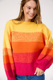 A model wearing the Valenza Jumper in colour Sunrise, from the front, cropped image
