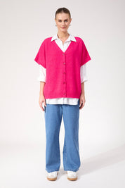 A model wearing the Valenza Knit Vest in colour Hotpink (Pink), from the front, showing the whole outfit