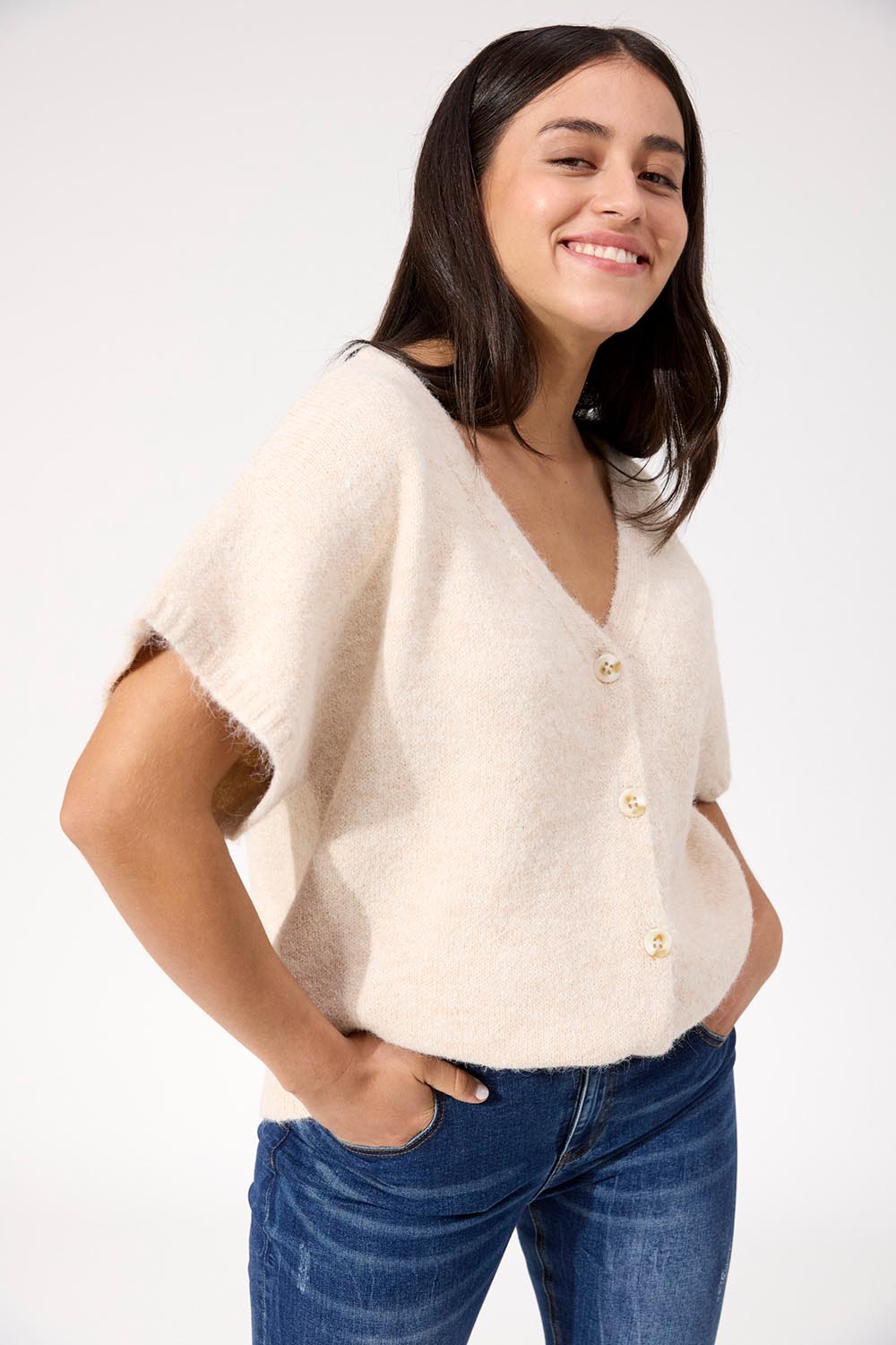 A model wearing the Valenza Knit Vest in colour Natural, from the front, cropped image