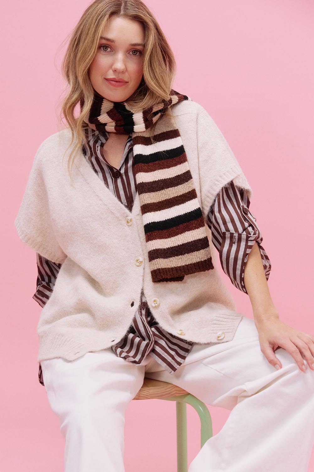 A model wearing the Valenza Knit Vest in colour Natural, from the front, showing the whole outfit