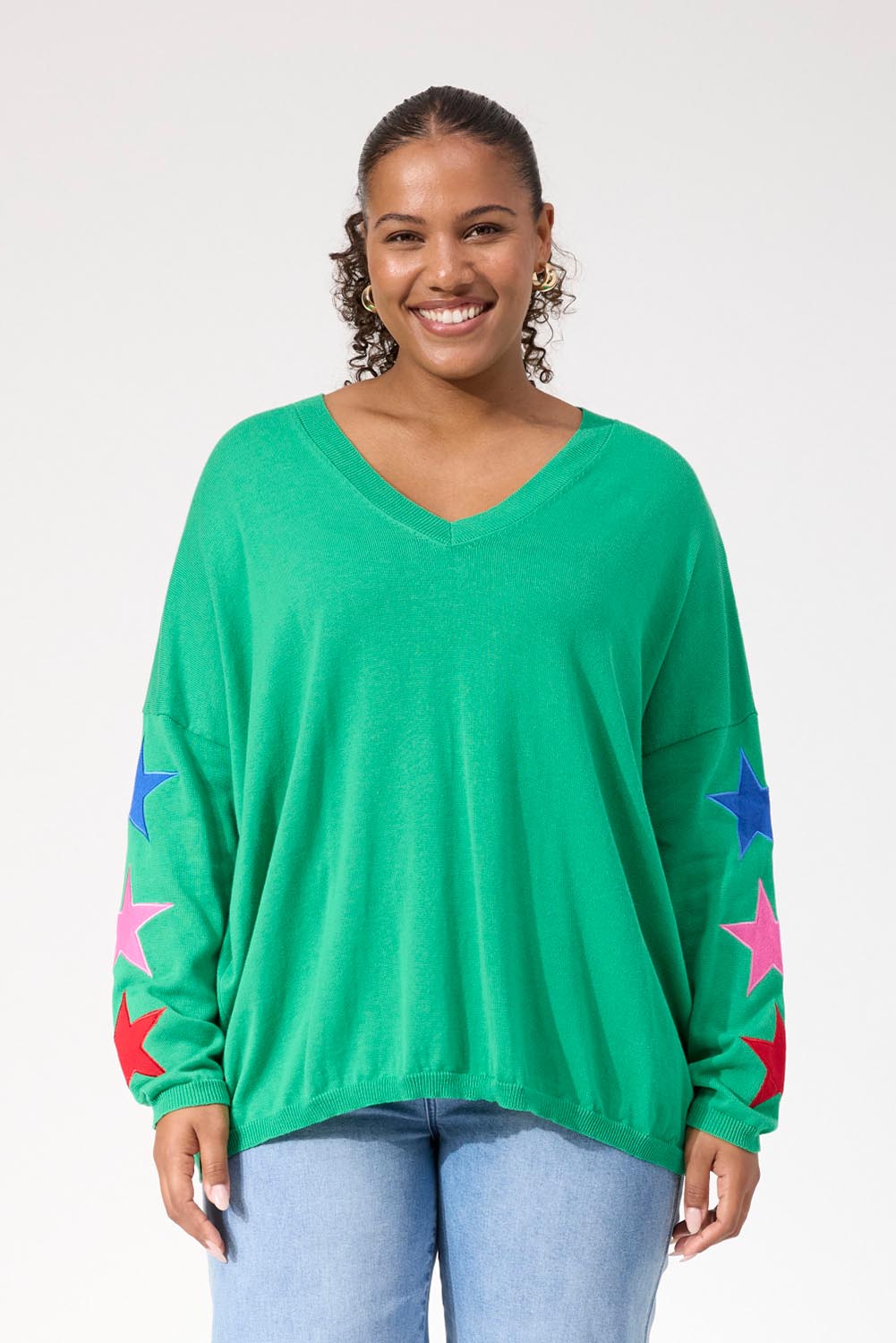 A model wearing the Vermont Star V Neck Jumper in colour Green (Green), from the front, cropped image