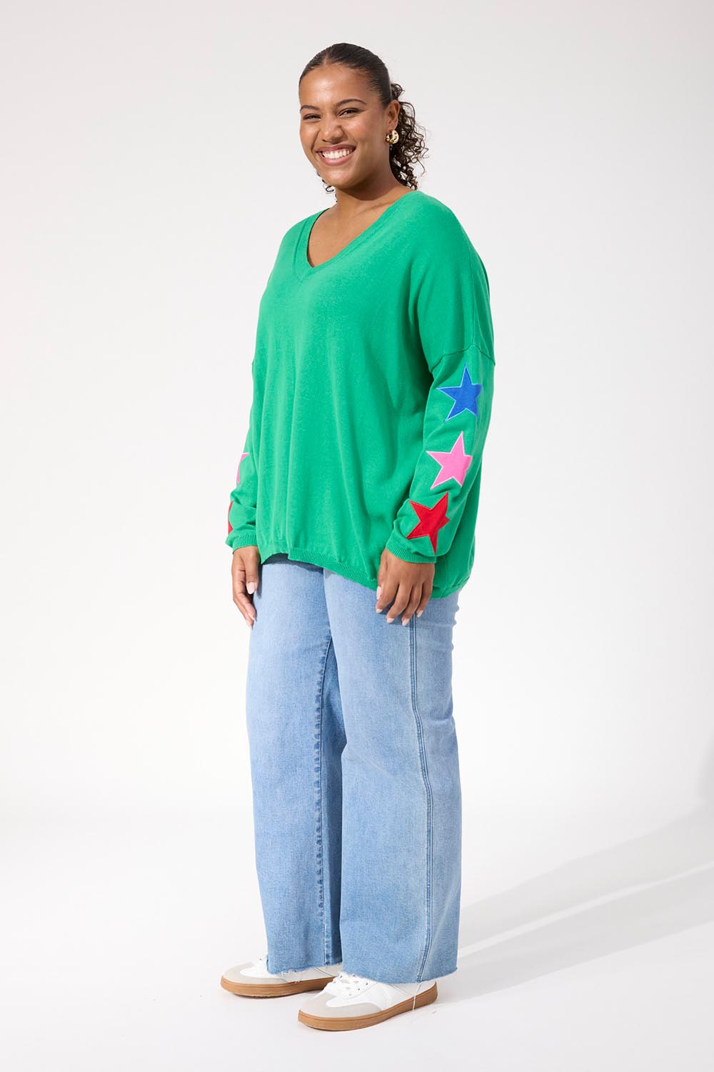 A model wearing the Vermont Star V Neck Jumper in colour Green (Green), from the front, showing the whole outfit