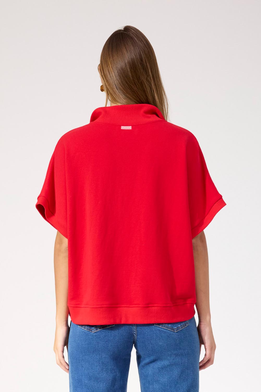 A model wearing the Boston Crop Sweat Top in colour Red (Red), from the back