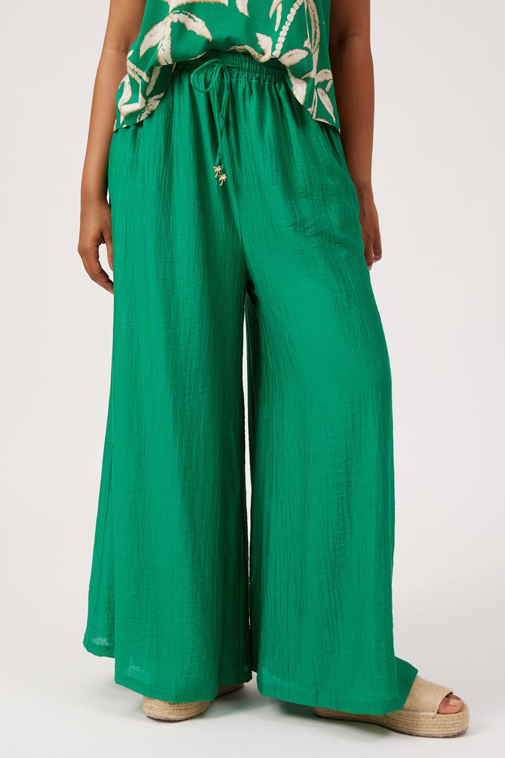 Model Genericm wearing size sample of the Kenya Palazzo Pant – Green in colour Green, in a cropped view