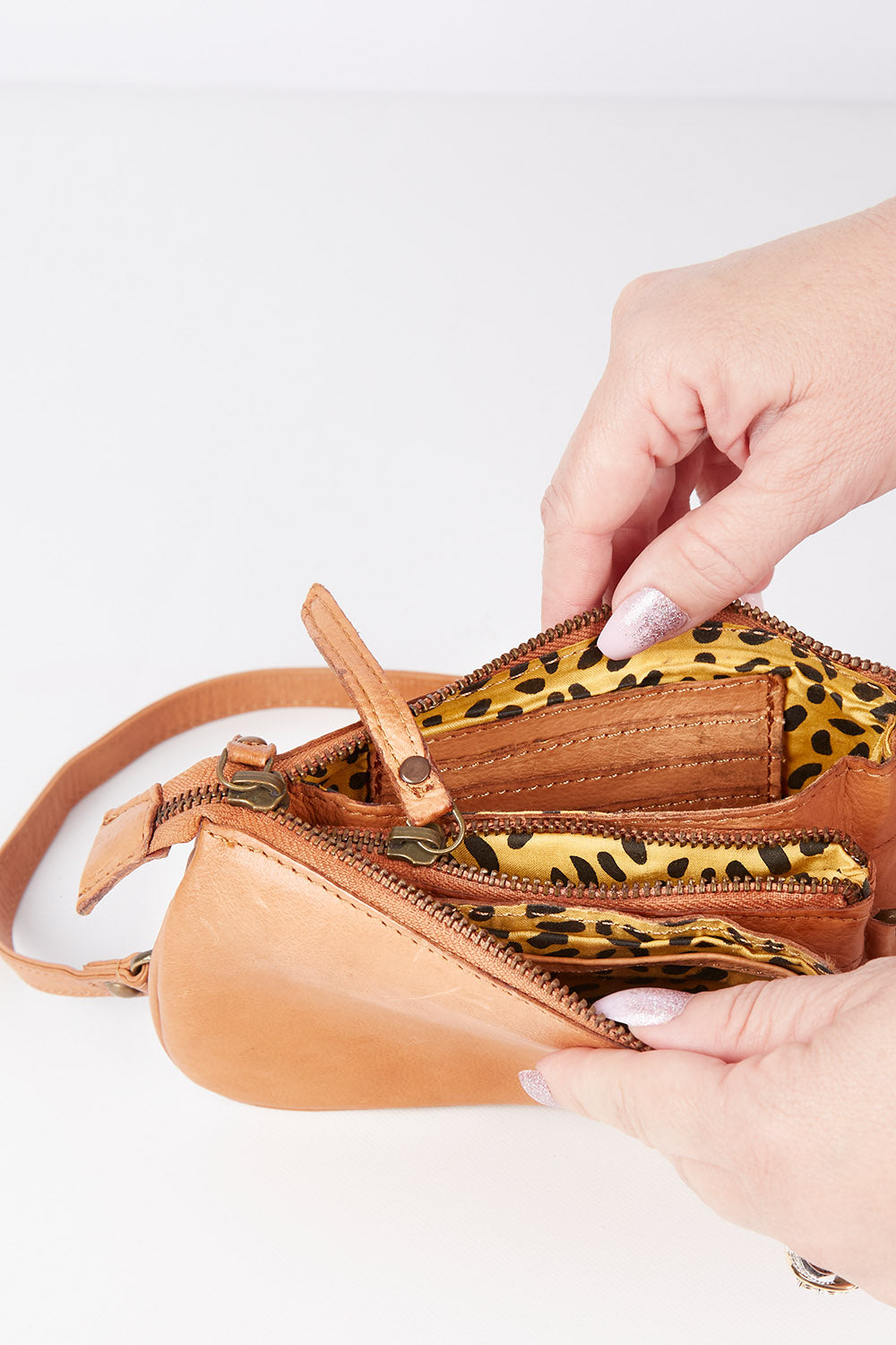 A model wearing size OneSize of the Brag Leather Crossbody Bag in colour Tan, from the front, showing the whole outfit