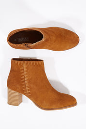 A model wearing size 6 of the Dylan Ankle Boot in colour TanSuede, from the front, showing the whole outfit