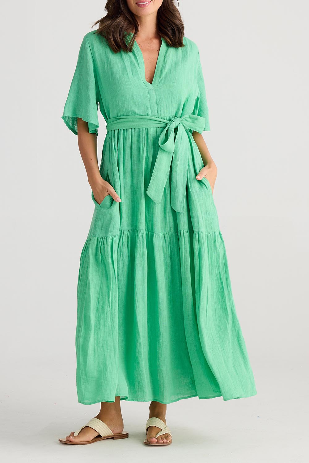 A model wearing the Lynwood Linen Dress in colour Apple (Green), from the front, cropped image