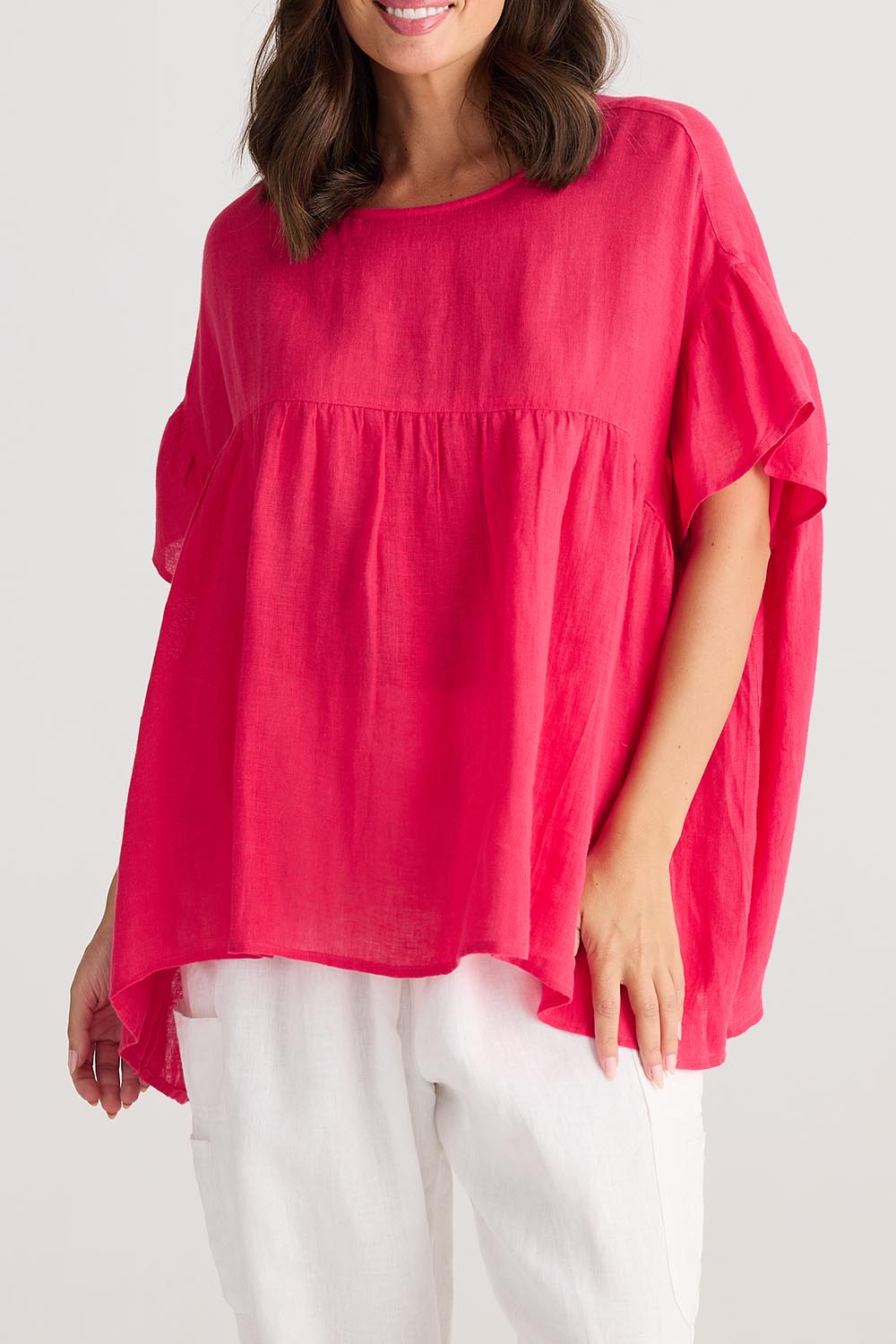 A model wearing the Caicos Linen Top in colour Raspberry (Blue), from the front, cropped image
