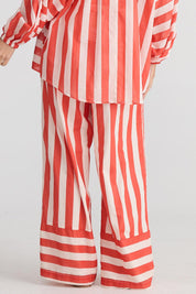 A model wearing the Mariah Cotton Pant in colour Noelstripe (Red), from the back