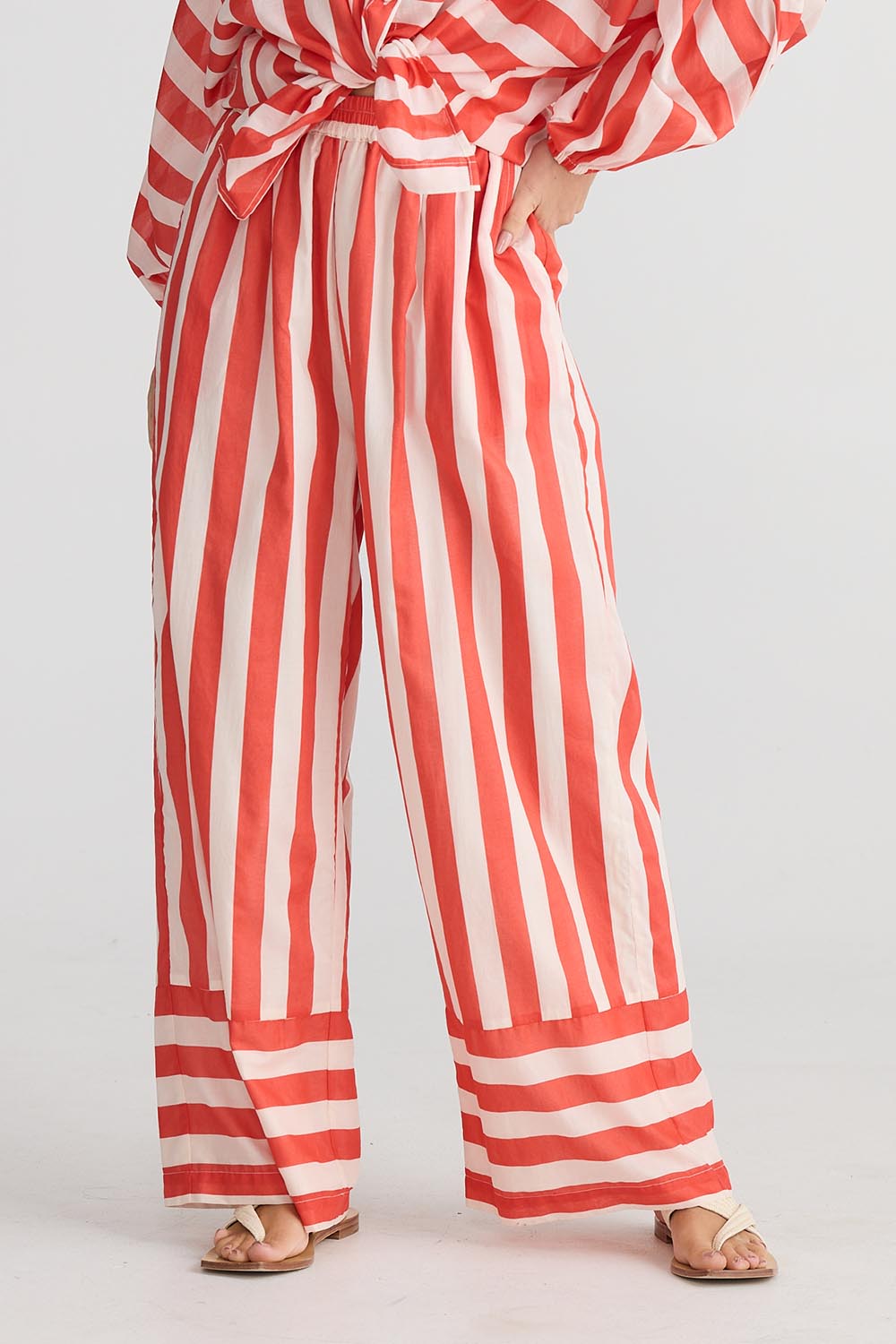 A model wearing the Mariah Cotton Pant in colour Noelstripe (Red), from the front, cropped image