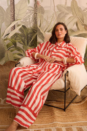 A model wearing the Mariah Cotton Pant in colour Noelstripe (Red), from the front, showing the whole outfit
