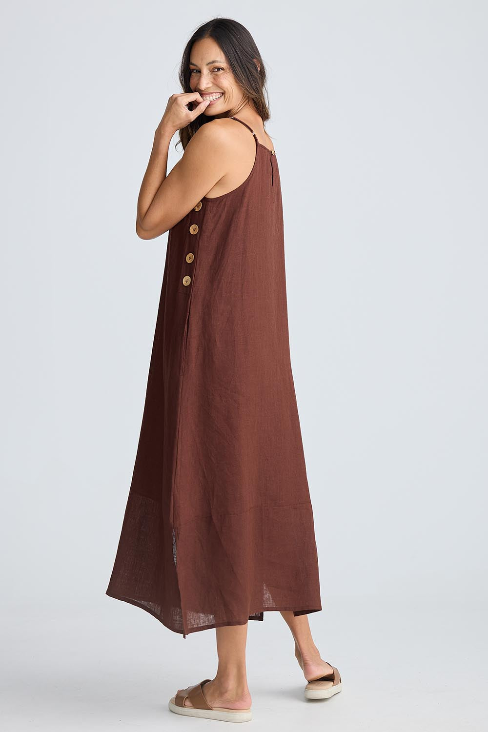 A model wearing the Cliffside Linen Maxi Dress in colour Chocolate, from the back