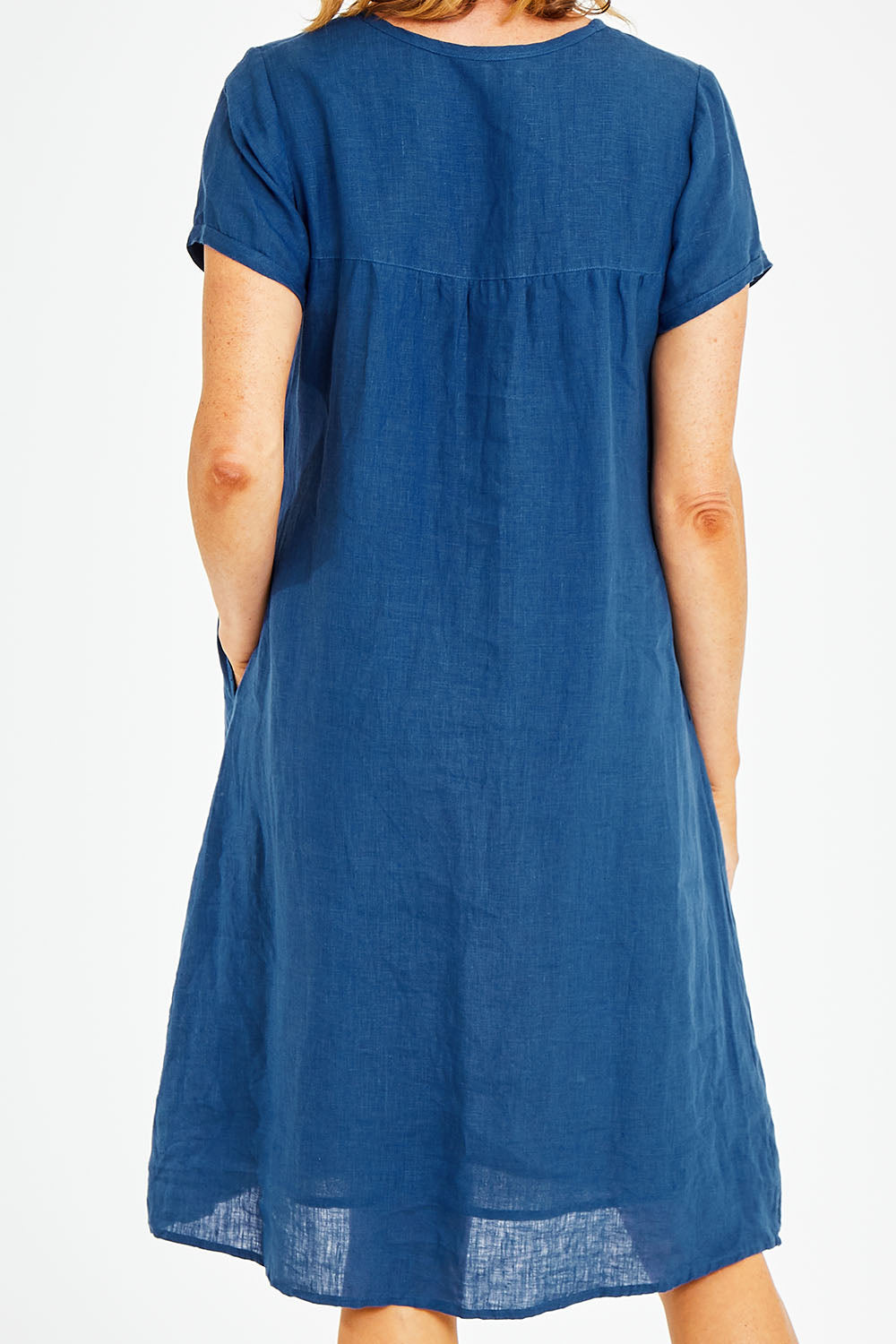 Model Naomi wearing size S of the Sabi Dress in colour Ocean (Blue), from the back