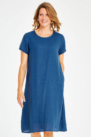 Model Naomi wearing size S of the Sabi Dress in colour Ocean (Blue), from the front, cropped image