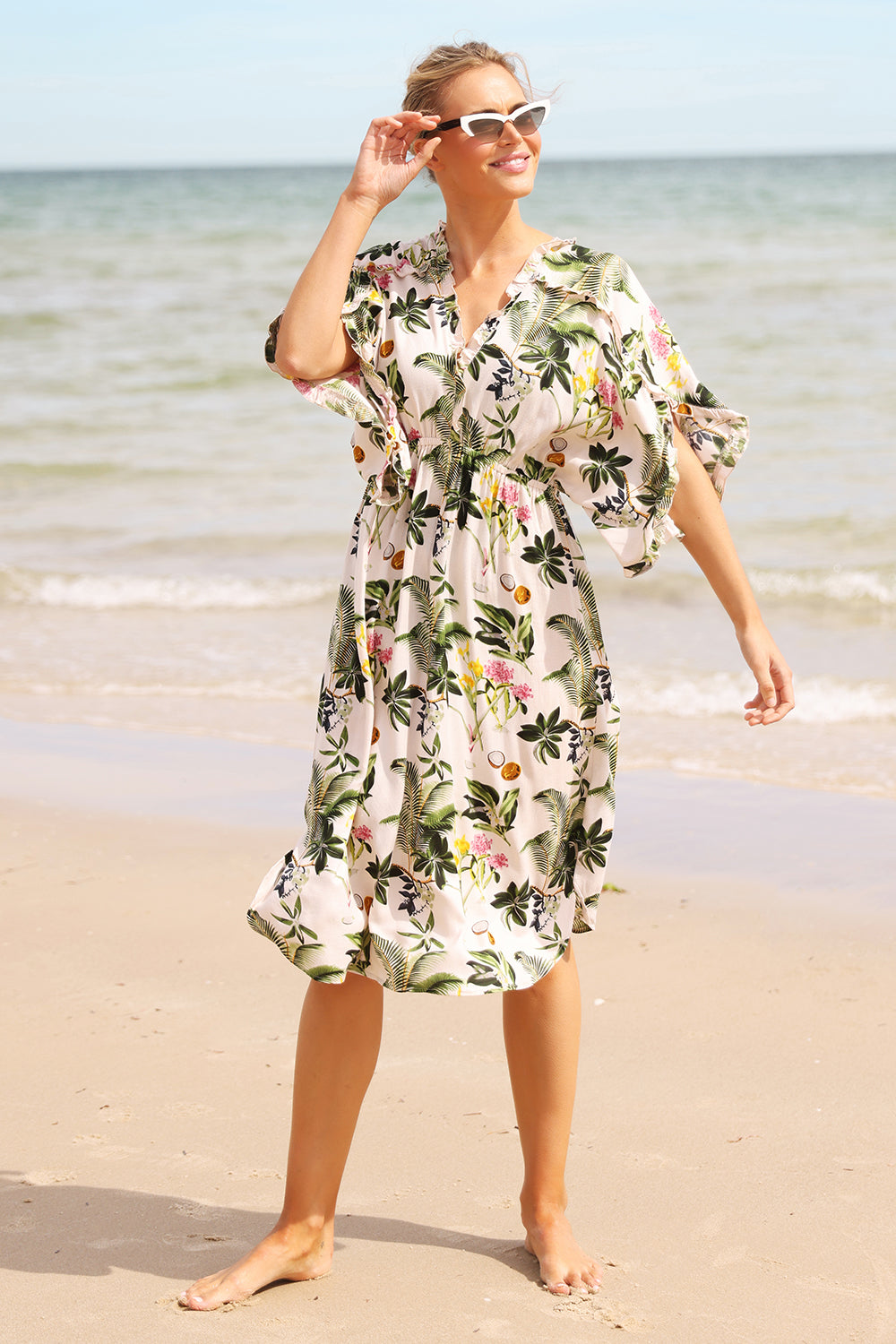 A model wearing the Chico Dress in colour Carribeaan (White), from the front, showing the whole outfit