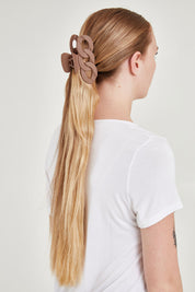A model wearing the Link Hair Claw Clip in colour Taupe, from the back