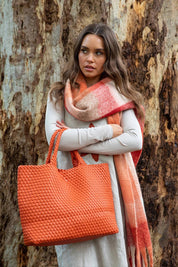 A model wearing the Detroit Woven Tote Bag in colour Burntorang, from the front, showing the whole outfit