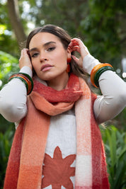 A model wearing the Cruz Scarf in colour Orange, from the front, showing the whole outfit