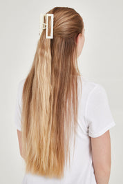 A model wearing the Bridget Hair Claw Clip in colour Ivory, from the back
