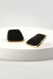 A model wearing the Fleur Earrings in colour Black (Black), from the front, showing the whole outfit