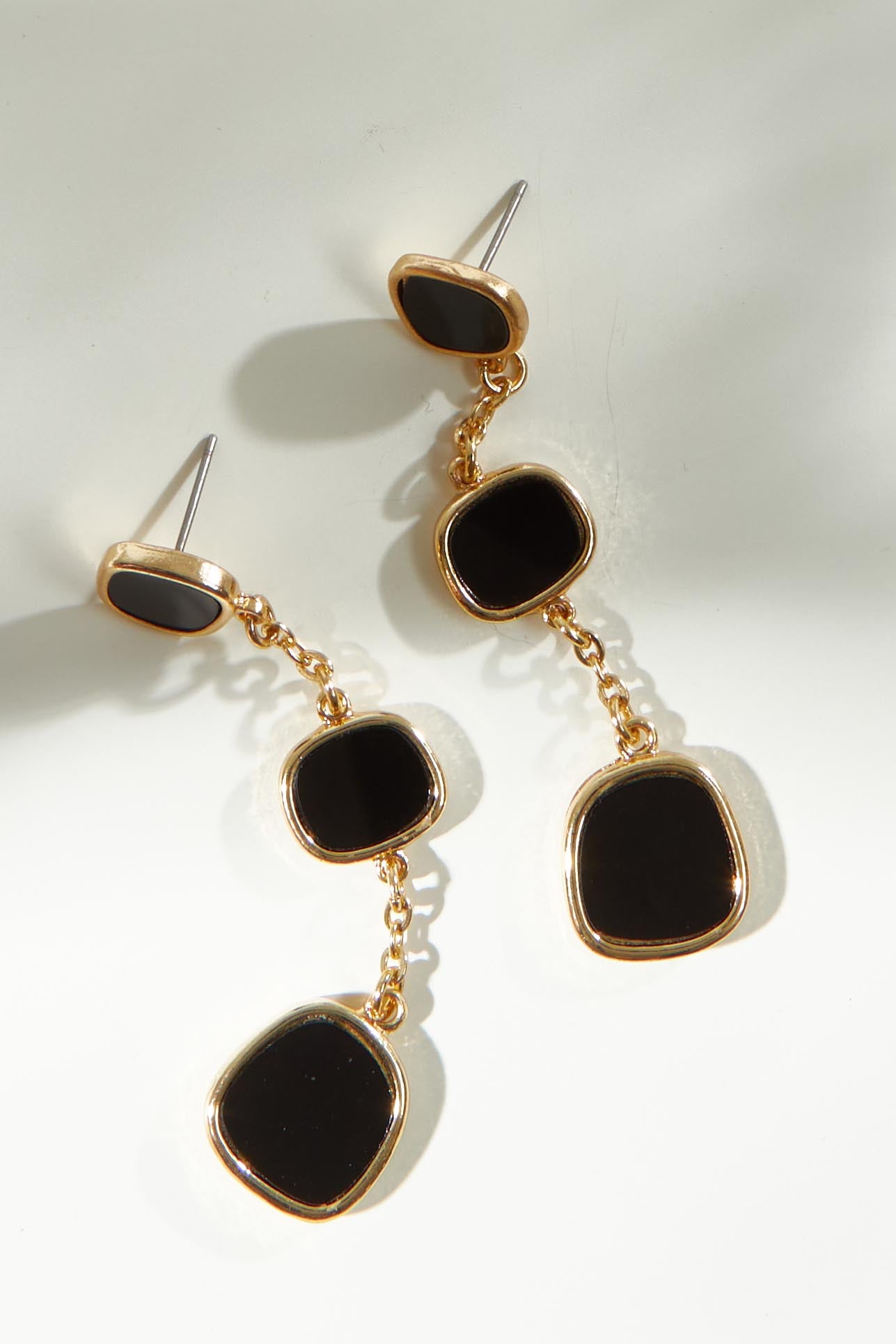 A model wearing the Joy Earrings in colour Black (Black), from the front, showing the whole outfit