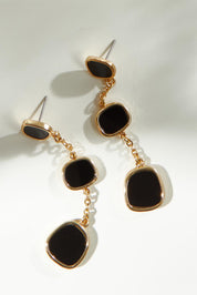 A model wearing the Joy Earrings in colour Black (Black), from the front, showing the whole outfit