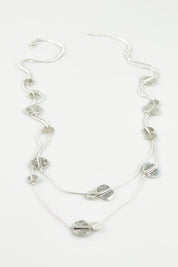 A model wearing the Toronto Necklace in colour Silver (Metallics), from the front, showing the whole outfit