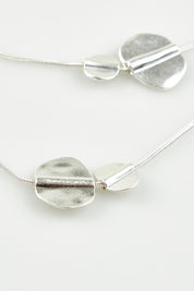 A model wearing the Toronto Necklace in colour Silver (Metallics), from the front, showing the whole outfit