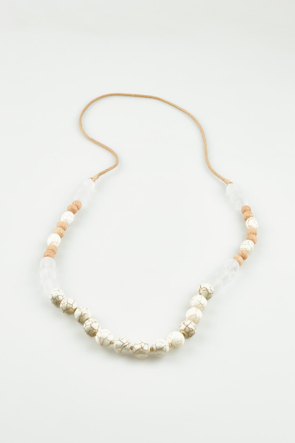 A model wearing the Madrid Necklace in colour Natural, from the front, showing the whole outfit