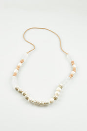 A model wearing the Madrid Necklace in colour Natural, from the front, showing the whole outfit