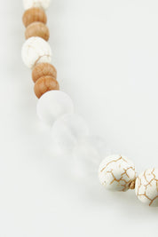 A model wearing the Madrid Necklace in colour Natural, from the front, showing the whole outfit